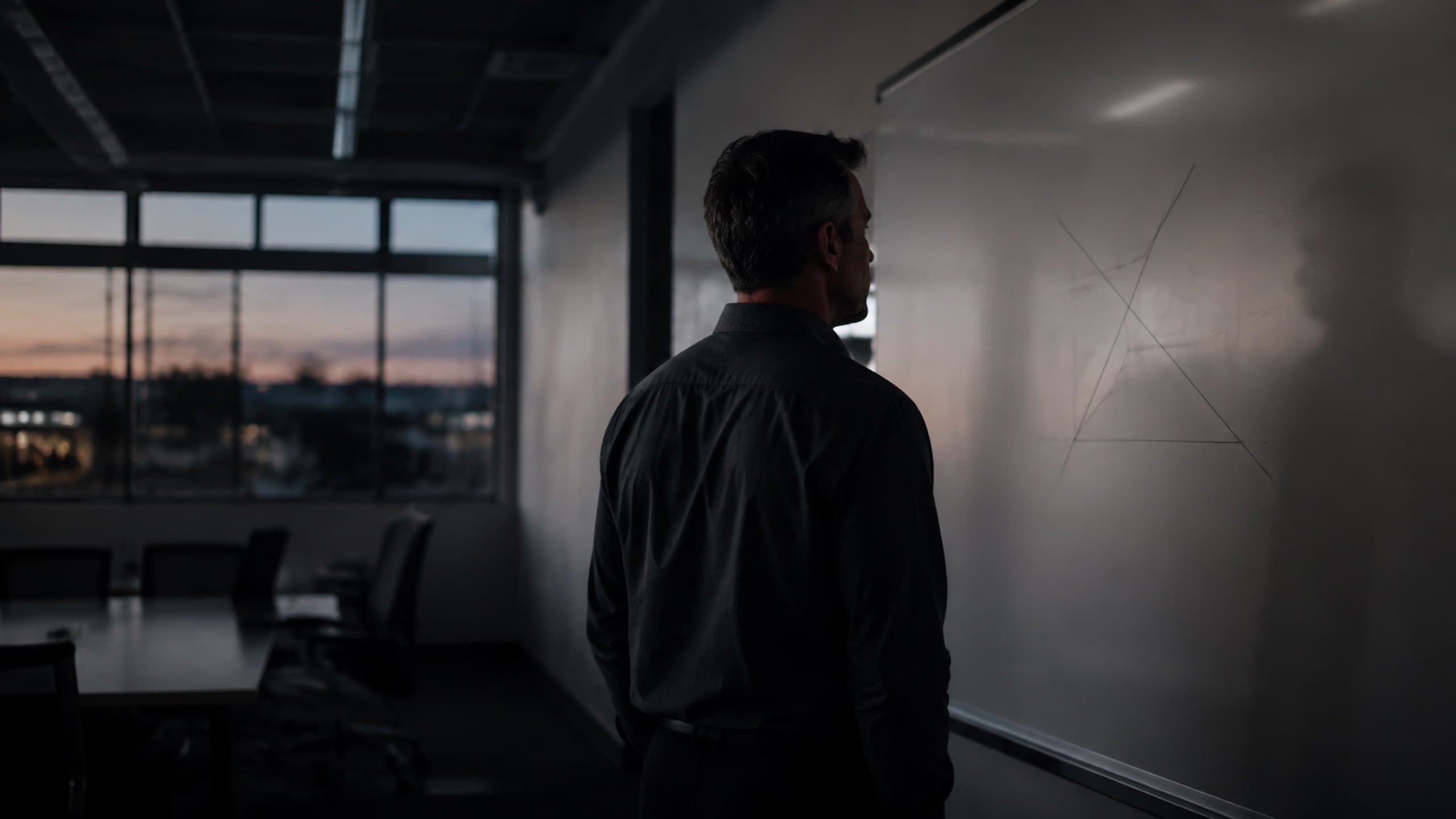 A manager working through a plan at a whiteboard